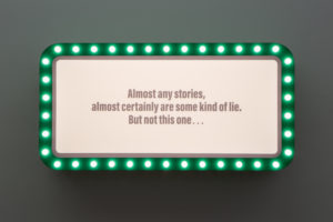 green light box with light bulbs on wall